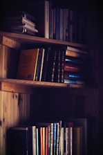 An inviting bookshelf filled with whimsical children's books under soft, earthy lighting.