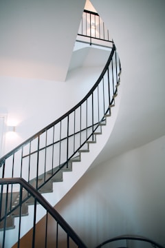 Spiral iron staircase with sleek black finish in a modern home interior.