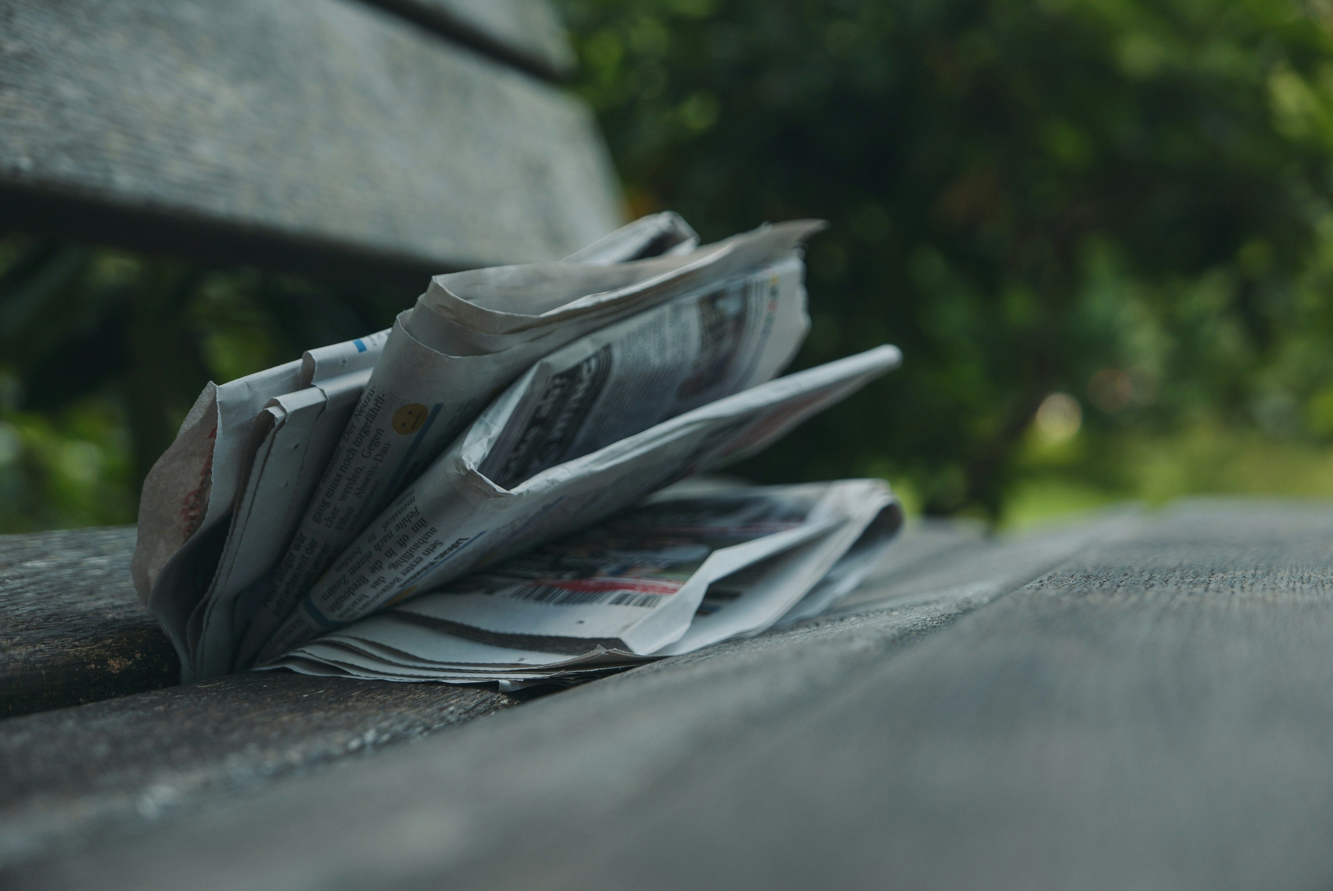 selective focus photography of newspaper on gray surface