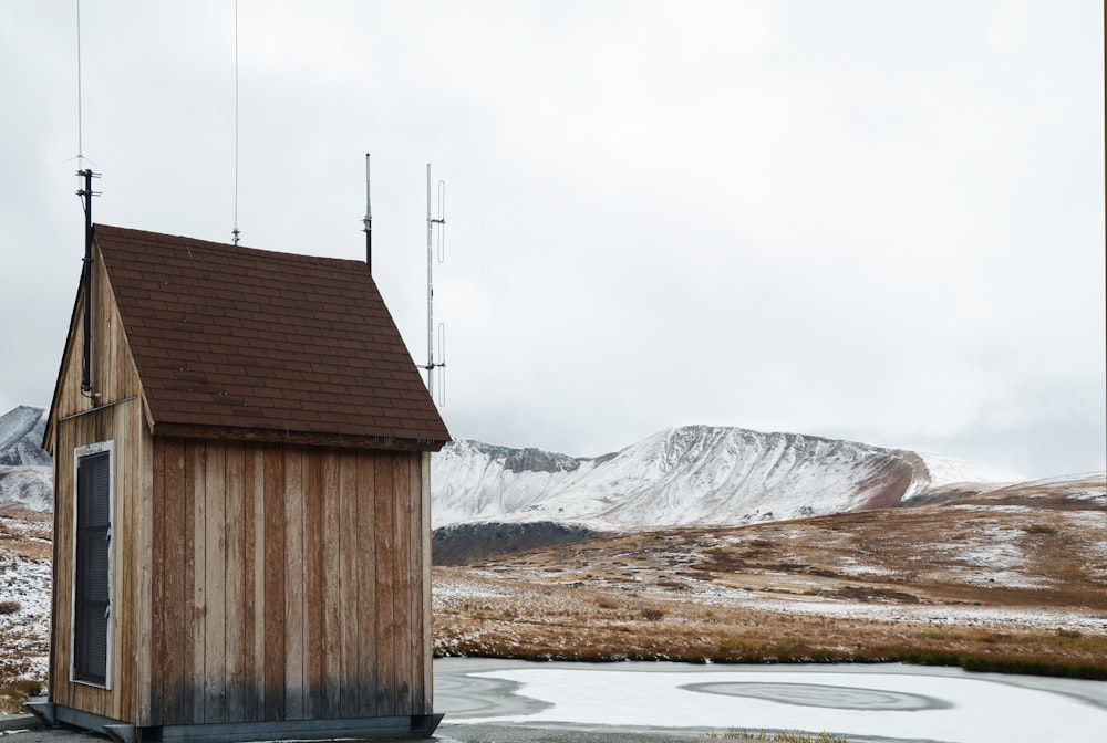 brown wooden shed near snow-covered land during daytime