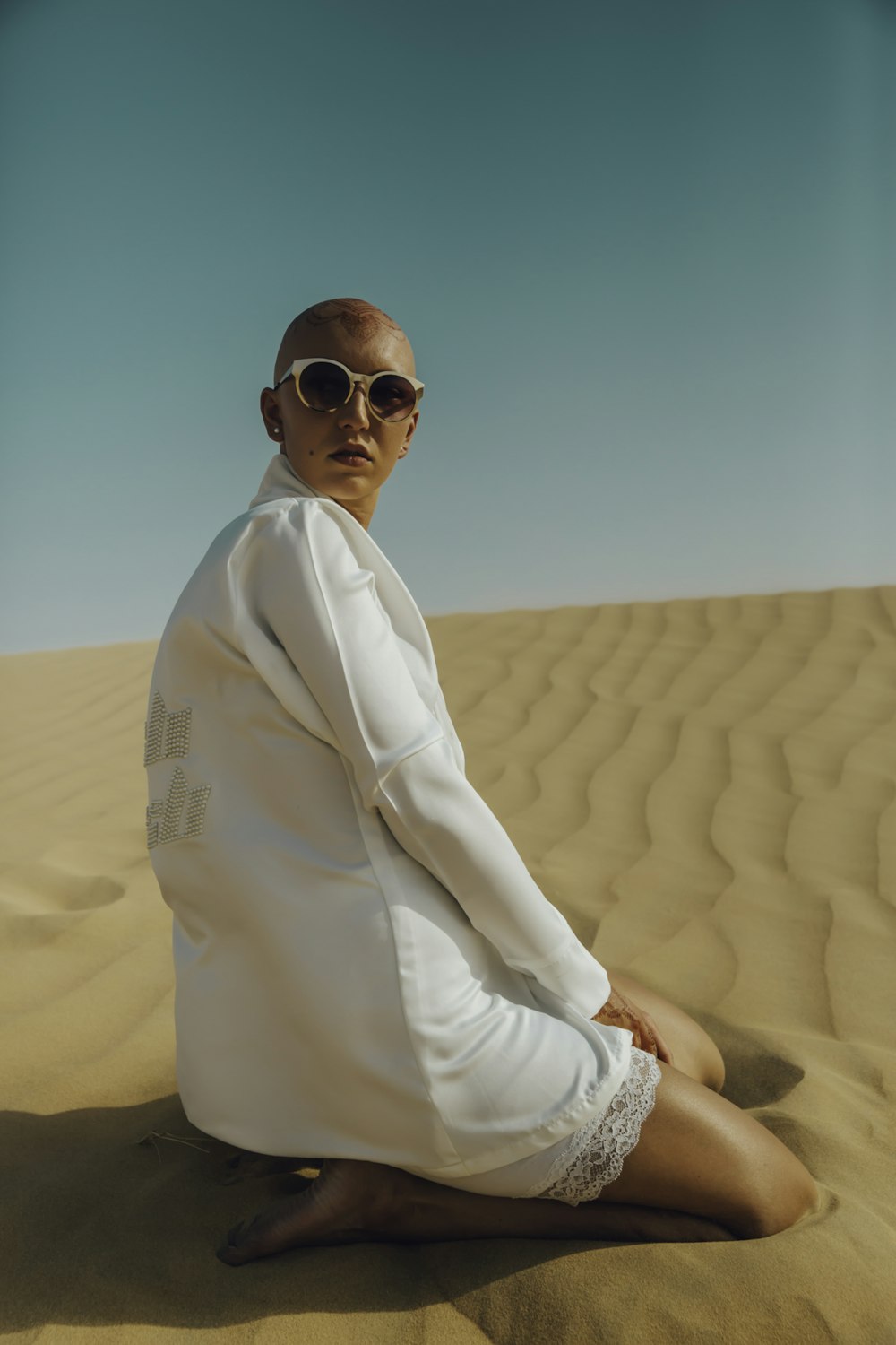 woman kneeling on brown sand taken at daytime