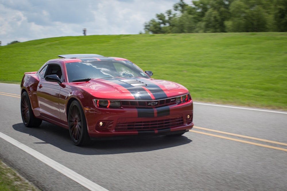 red and black Chevrolet coupe on roadway