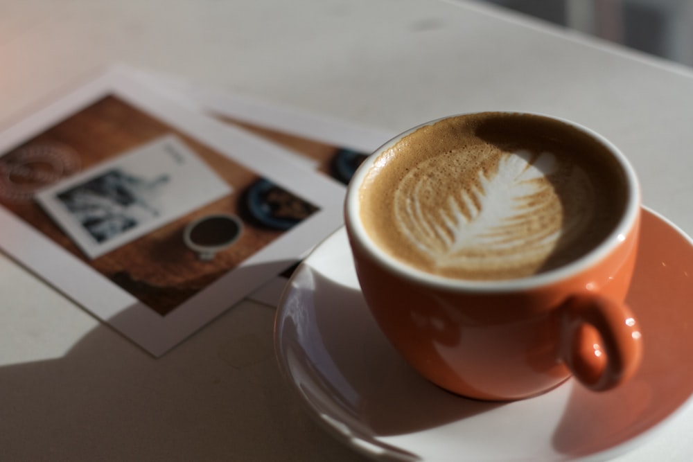 café dans une tasse en céramique orange sur soucoupe