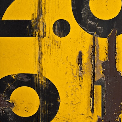 a close up of a yellow and black sign with numbers