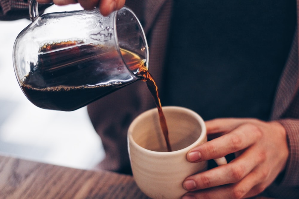 person pouring coffee on mug