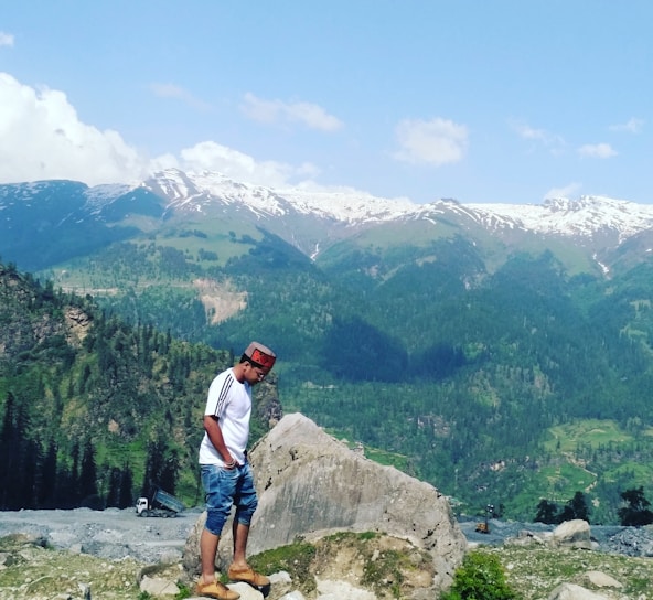 A close-up of the Karpatyman hat resting on a rocky mountain ledge with the Carpathian mountains in the background.