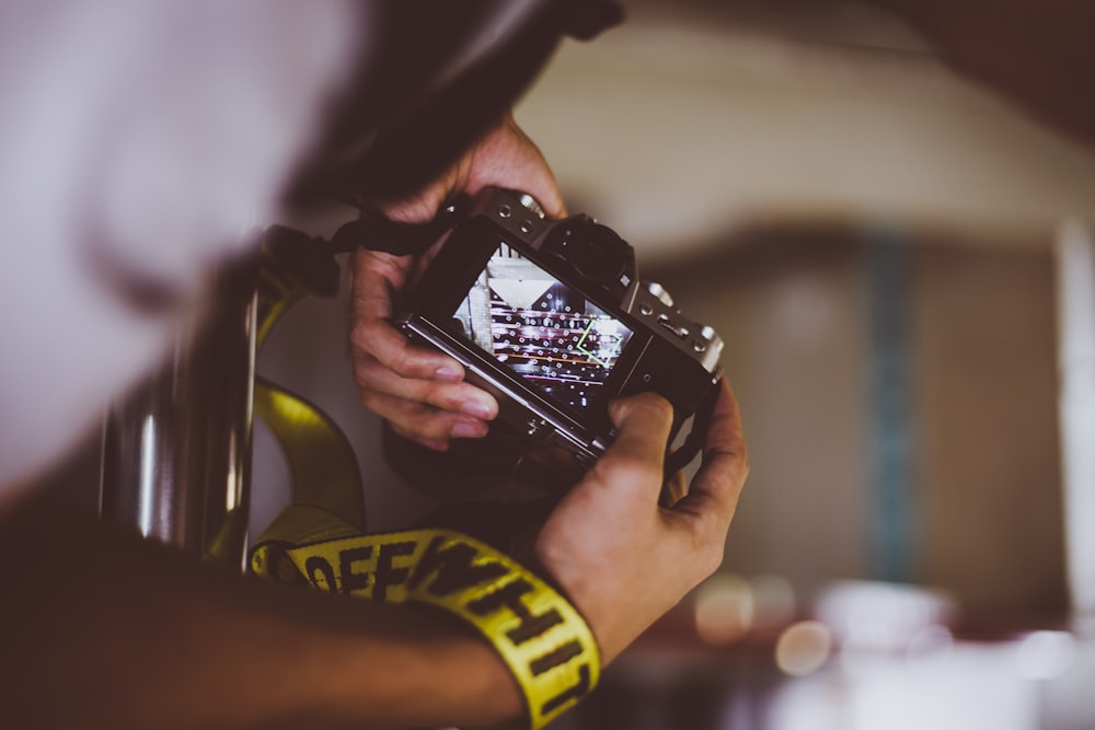 person holding camera looking at screen