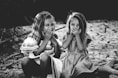 grayscale photography of two girls closing their mouths