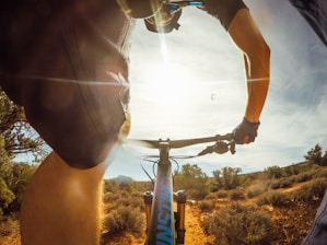 person riding bike near plants