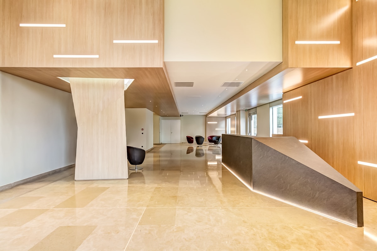 Bright reception area with wood panelling, stone floor and a long front desk