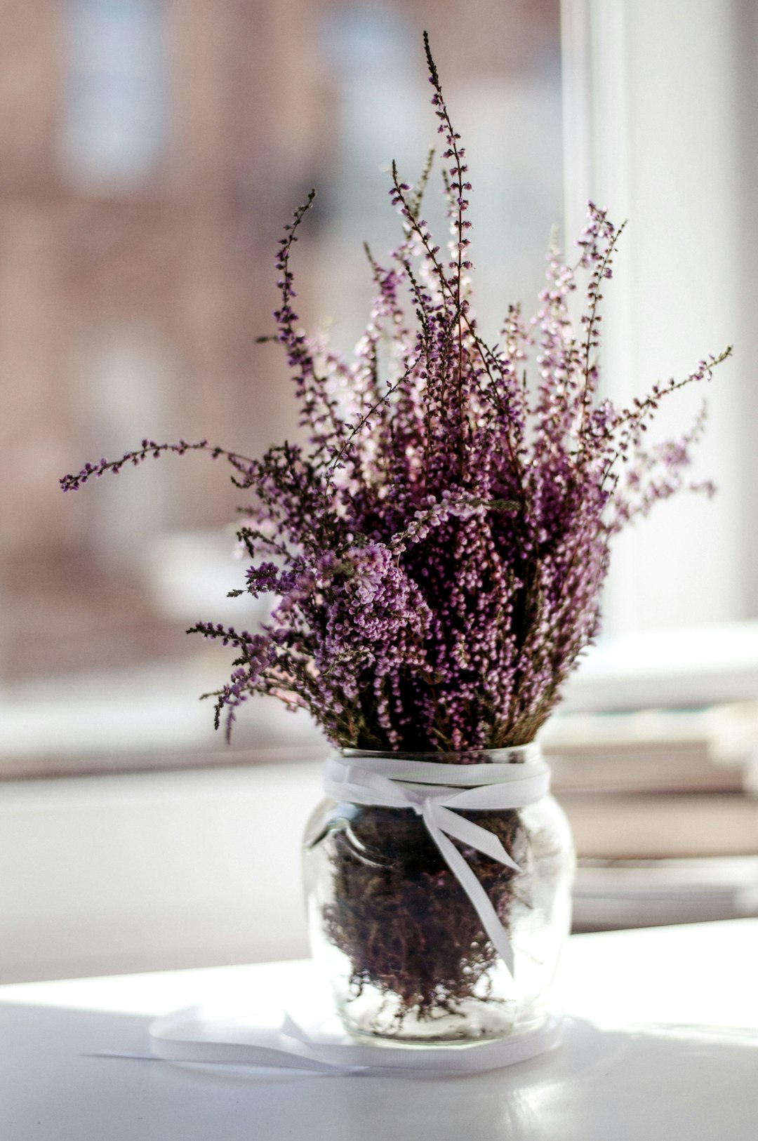 pink petaled flower with clear glass vase centerpiece