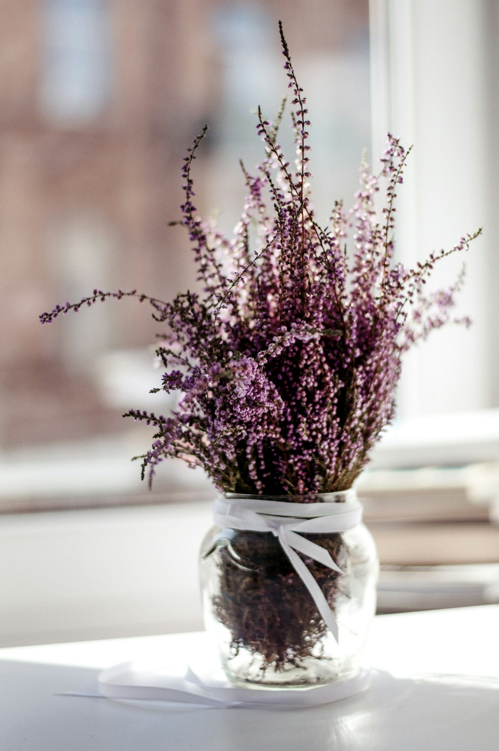 flor de pétalas cor-de-rosa com vaso de vidro transparente peça central