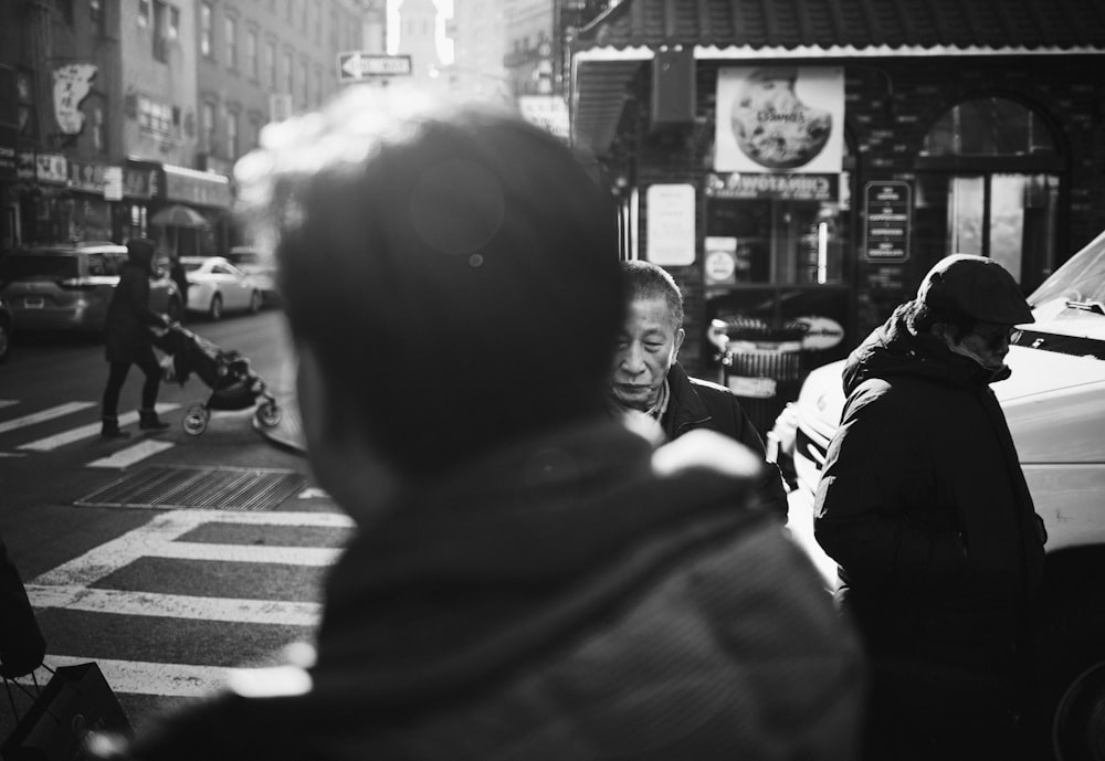 grayscale photography of man crossing road