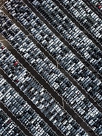 A wide view of a newly striped parking lot bustling with cars.