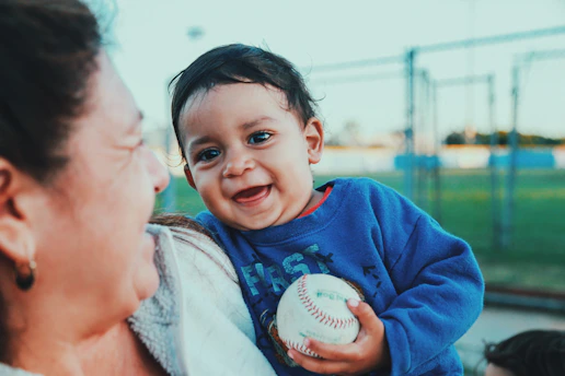 Volunteers and kids sharing smiles at an international baseball event