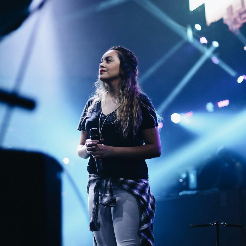 woman wearing black scoop-neck t-shirt person holding black wireless microphone