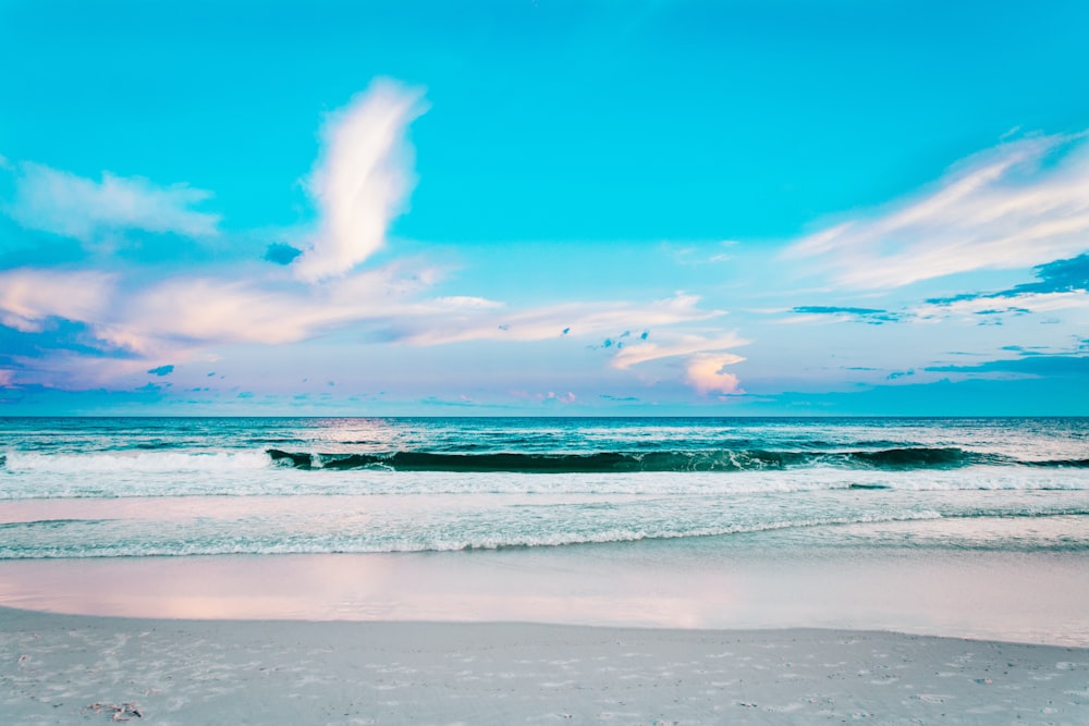 seashore under blue cloudy sky