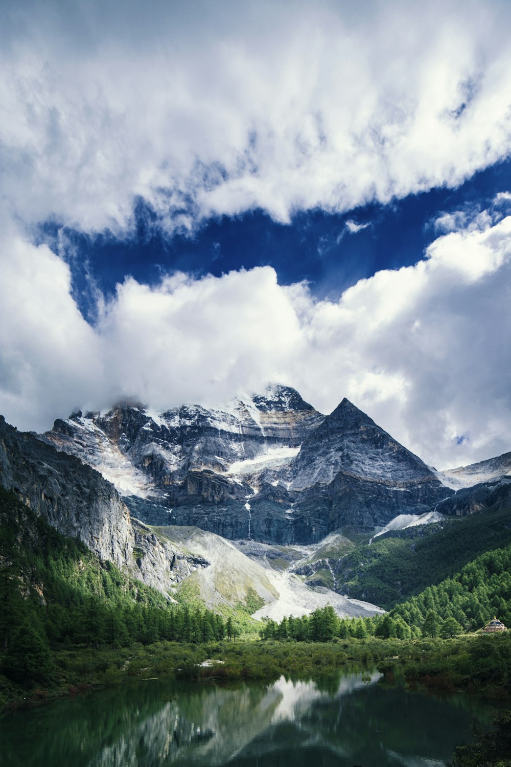 fotografia de paisagens de montanhas, plantas e rios sob nuvens