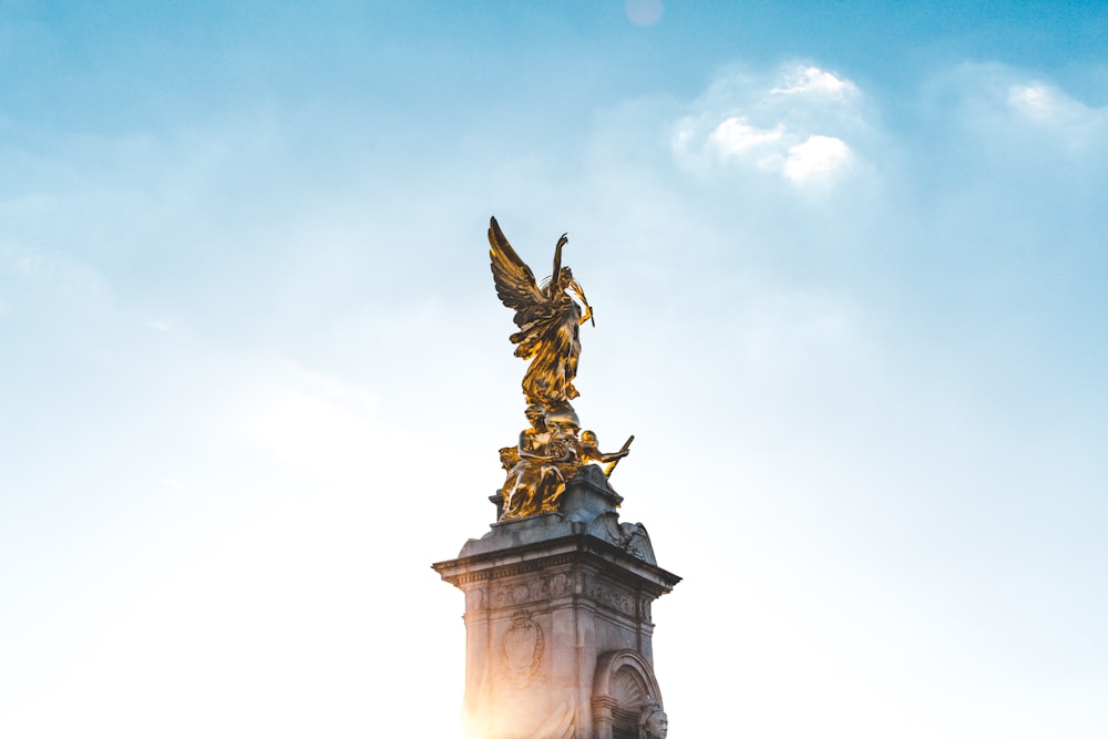 Estatua de ángel dorado bajo el cielo azul