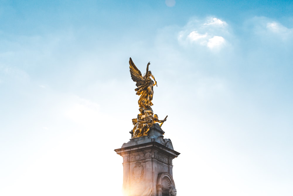 Estátua do anjo de ouro sob o céu azul