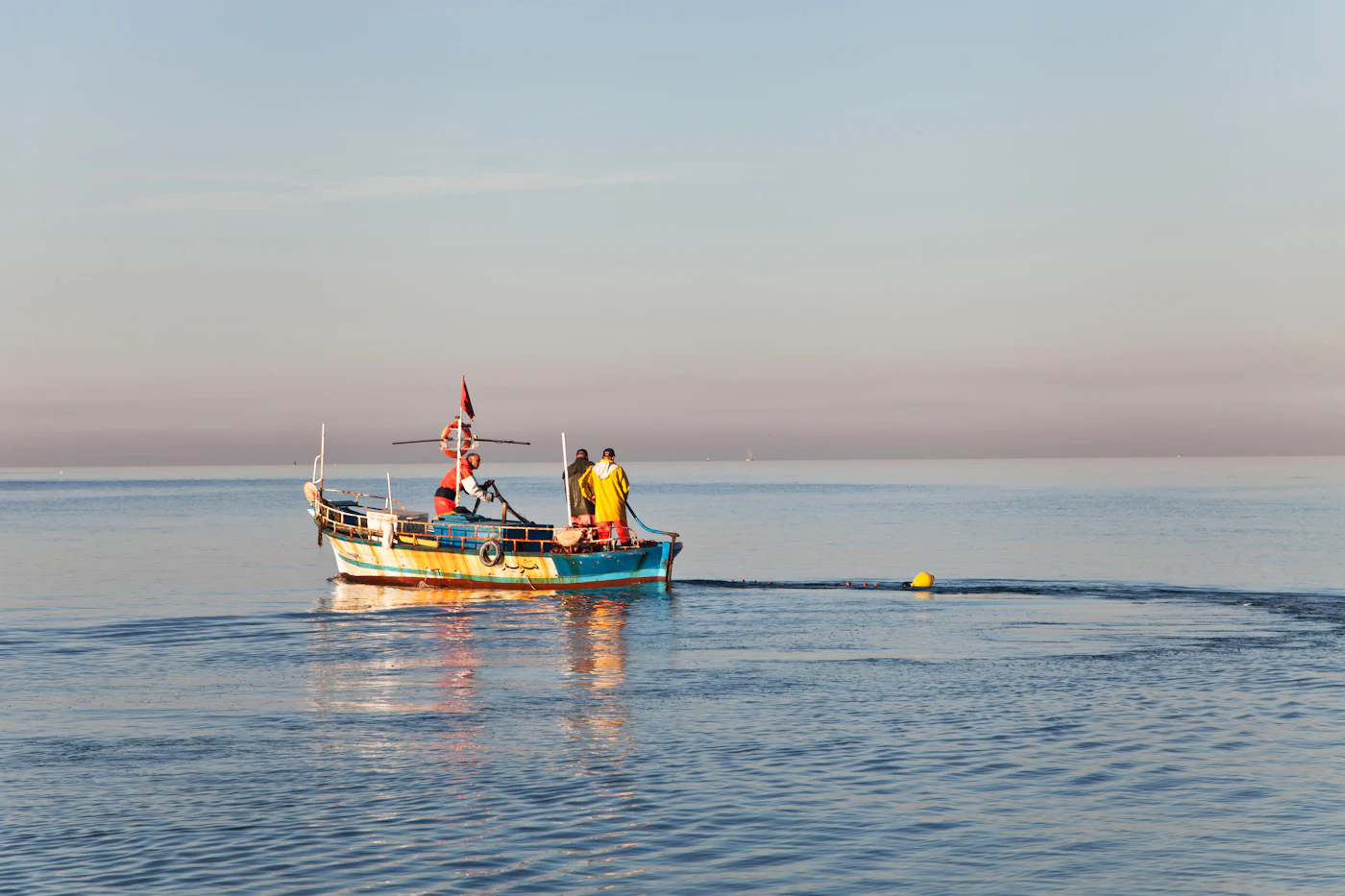 Small fishing boat on a calm sea at first light