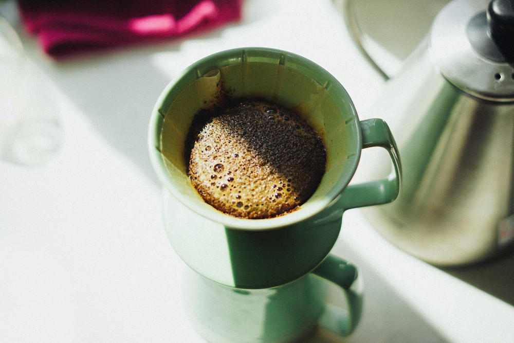 白いテーブルの上の茶色のマグカップに入った茶色の飲み物