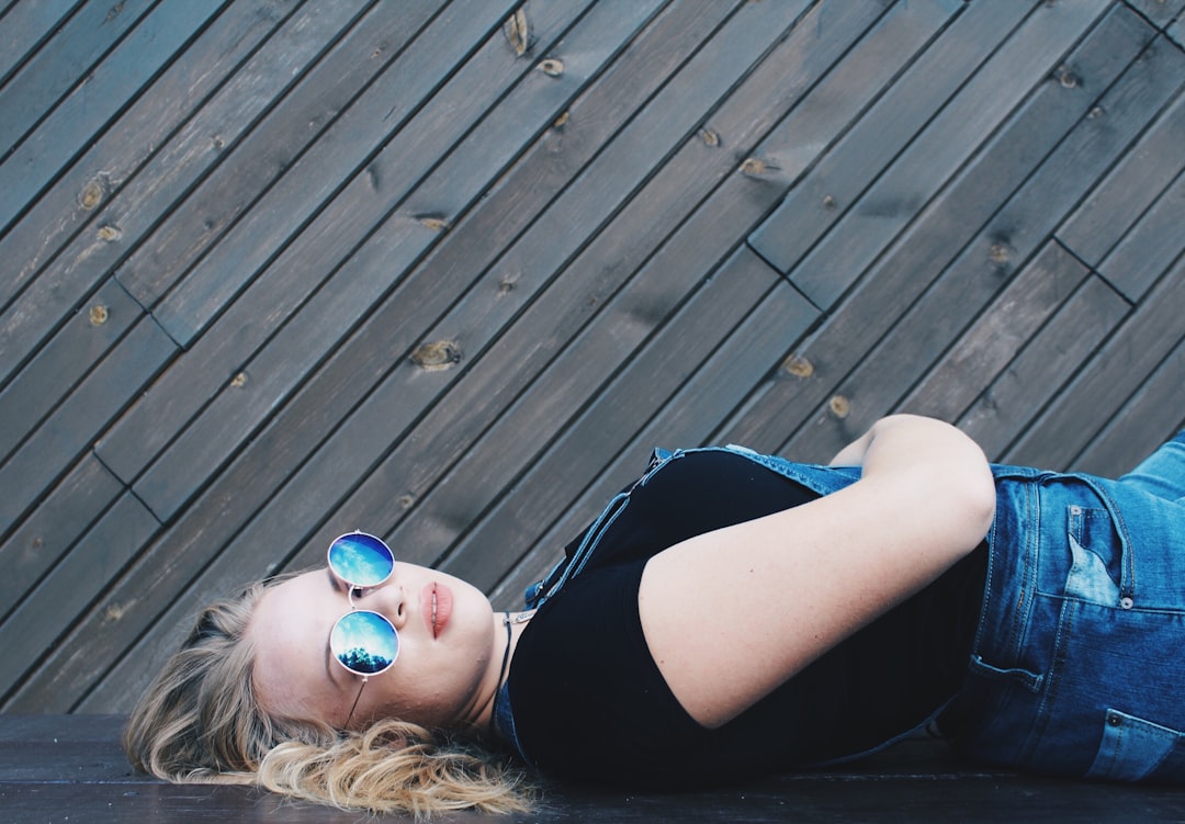 woman laying on black surface taking selfie photo