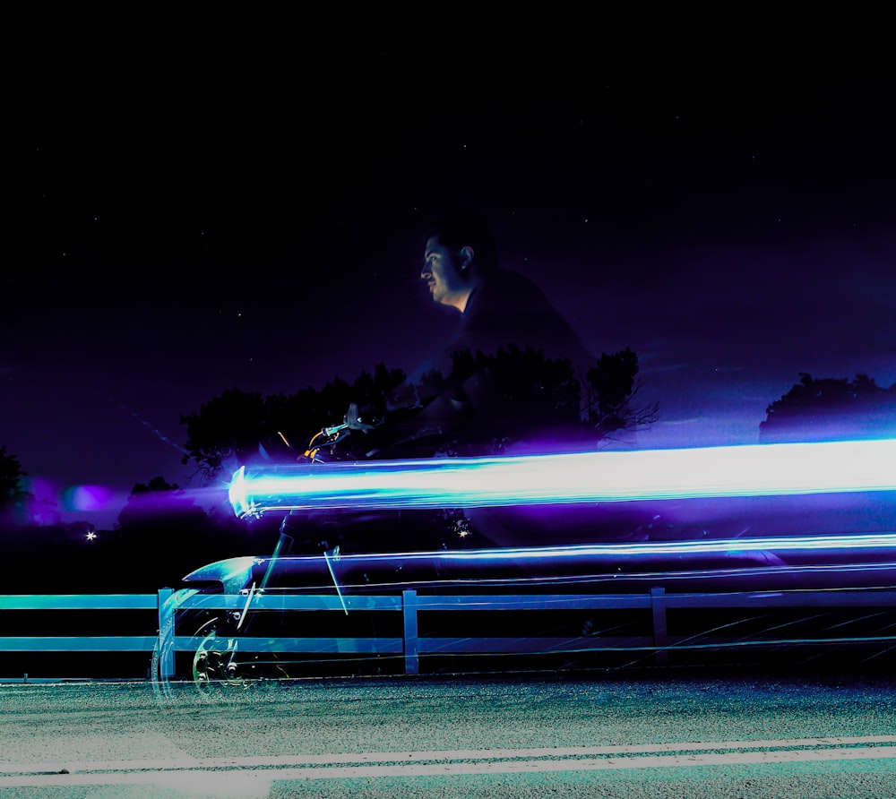 person riding motorcycle during night in time-lapse photo