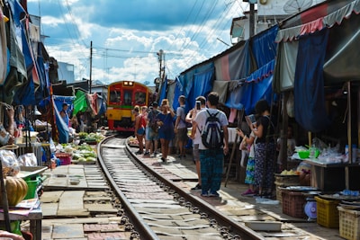 person standing near red and orange train during daytime