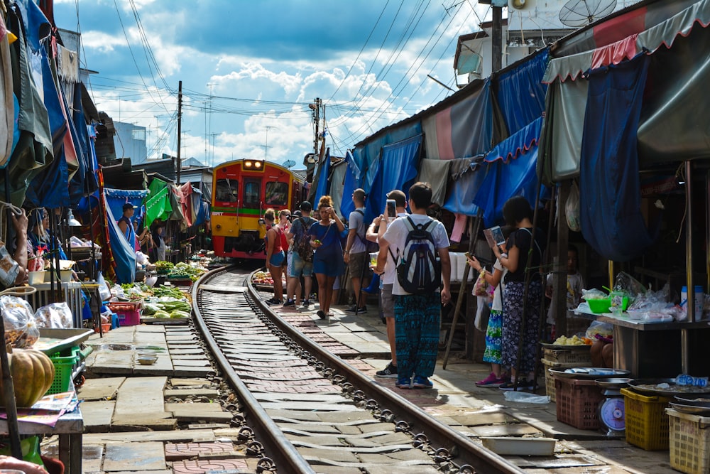 person standing near red and orange train during daytime