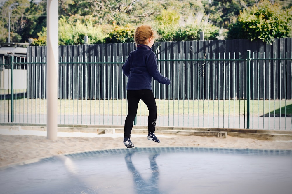 girl in blue sweater jumping