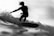 grayscale photo of man riding a surfboard