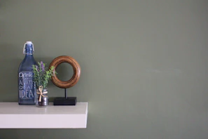 A minimalist kitchen shelf with oleivo olive oil pouch next to natural wine bottles