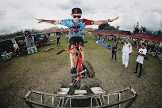 boy doing bicycle tricks in front of many people