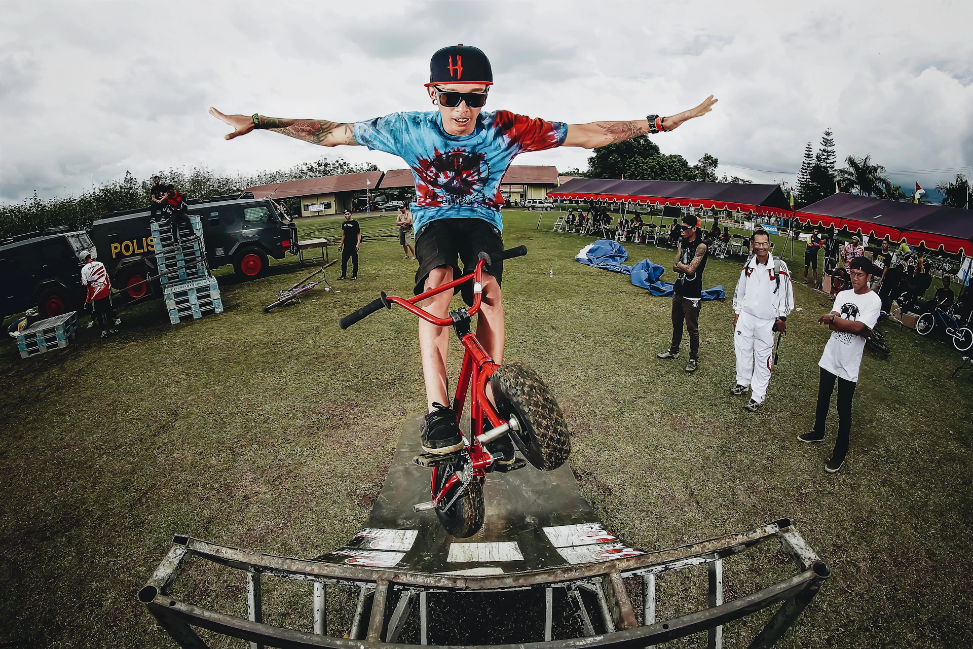 boy doing bicycle tricks in front of many people