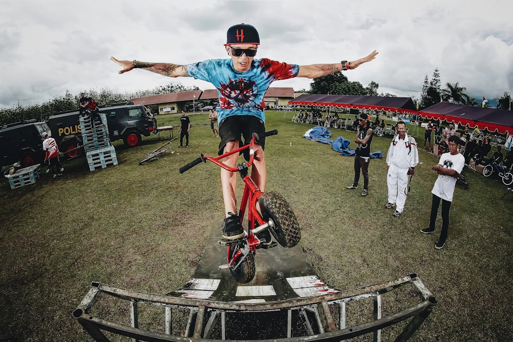 boy doing bicycle tricks in front of many people