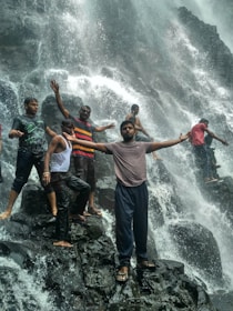 Smiling group photo after a canyoning tour, surrounded by towering cliffs and sparkling streams.