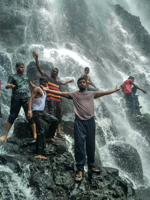 Friends gathered by a serene waterfall, capturing the joy of discovery together.
