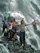 A joyful group of college students posing with backpacks in front of a lush Kerala waterfall.