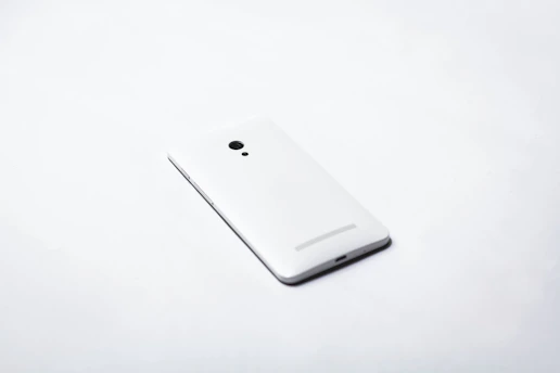 Close-up of a sleek black and blue smartphone on a minimalist white surface.