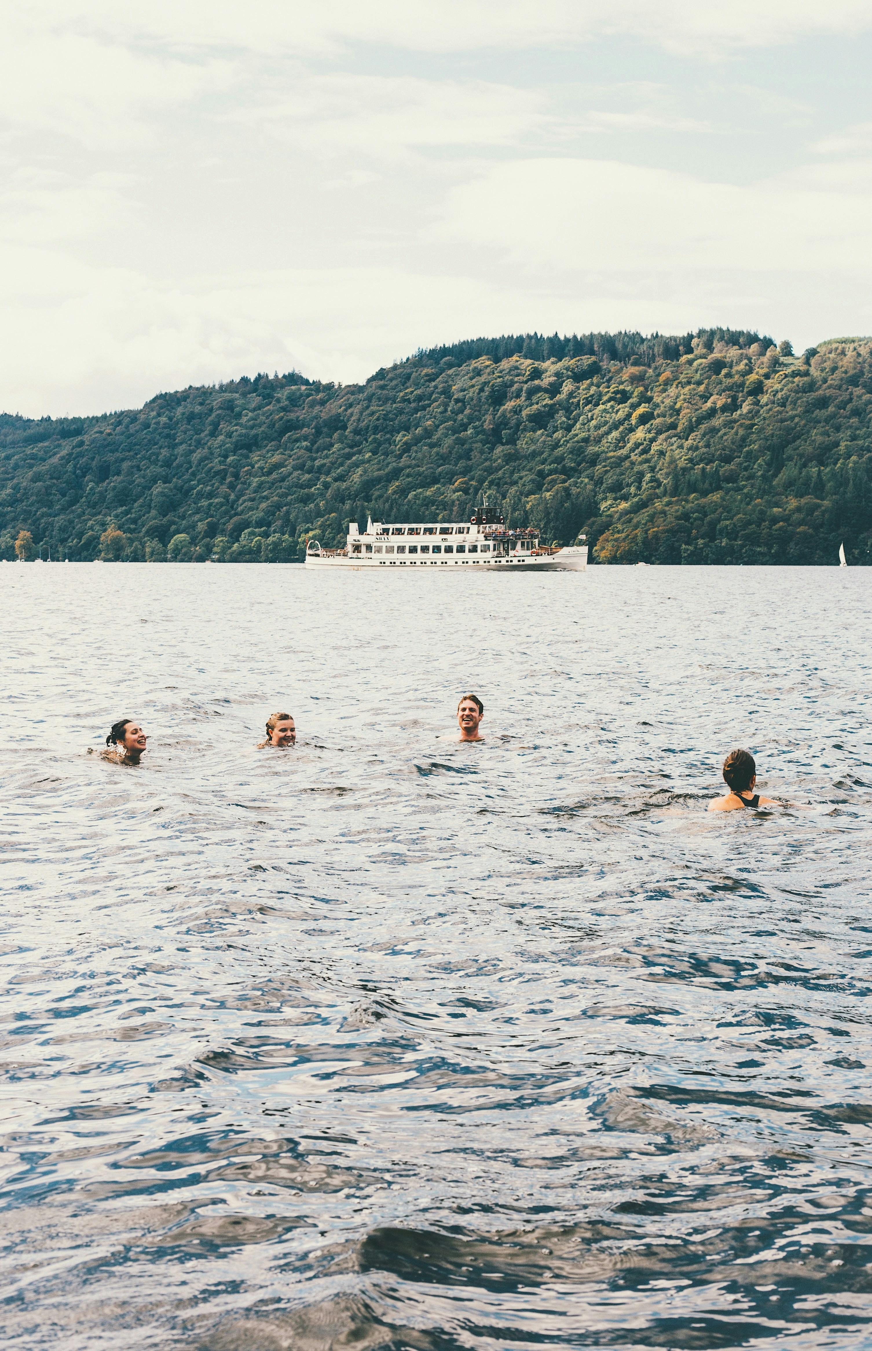 four people swimming in water