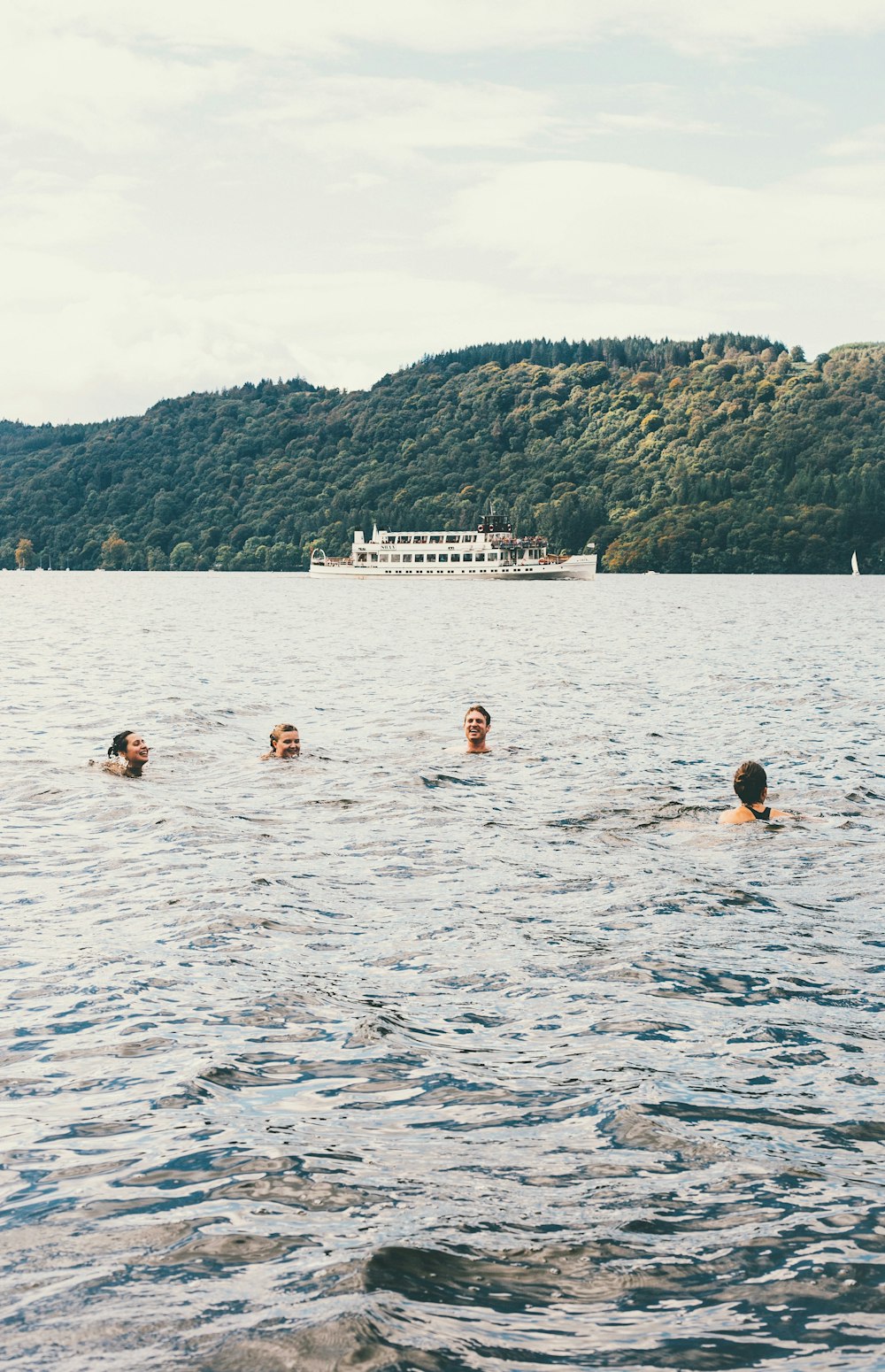 Cuatro personas nadando en un cuerpo de agua