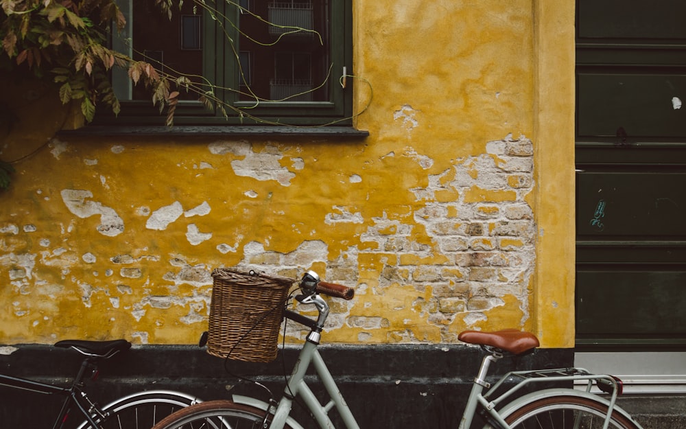 gray bicycle leaning on brown wall
