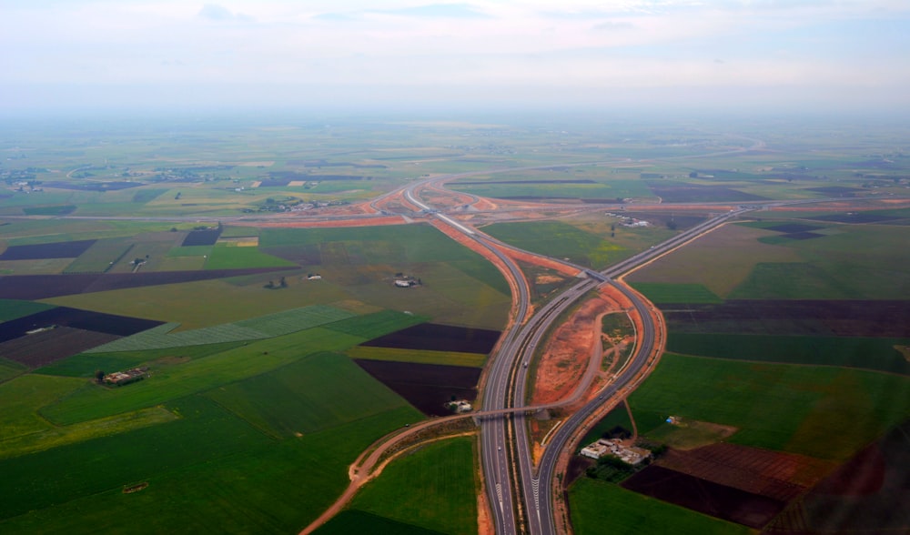 aerial view of freeway between green fields