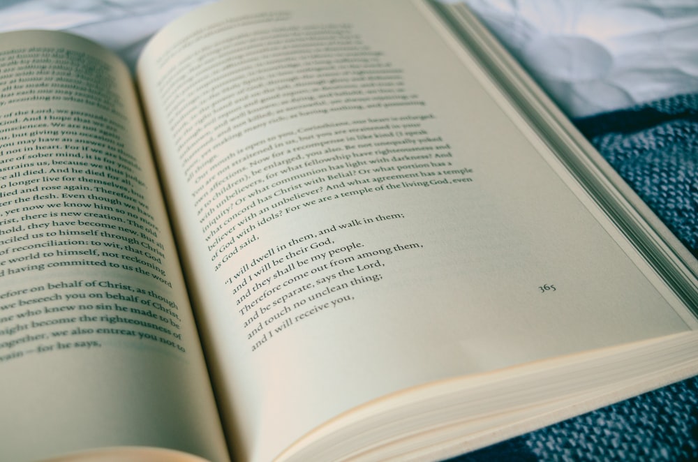 book opened on top of white bed comforter