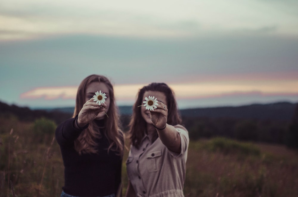 two women holding flowers