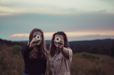 two women holding flowers friends zoom background