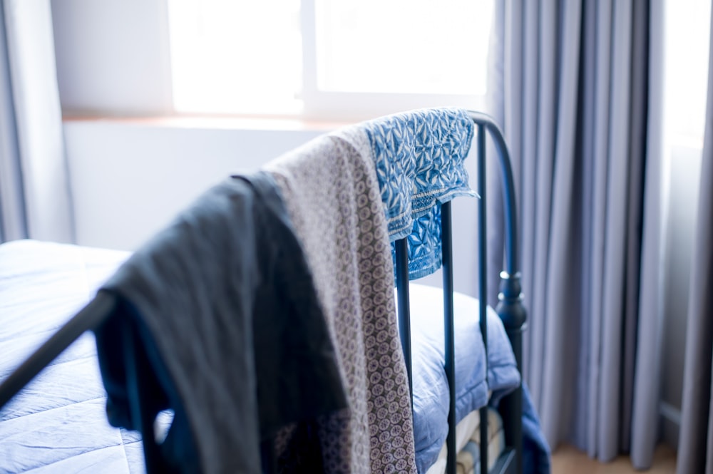 white and gray textile on blue steel bed frame