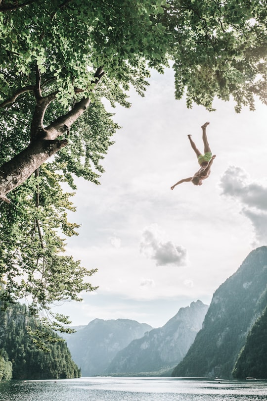 person diving on body of water in Königssee Germany