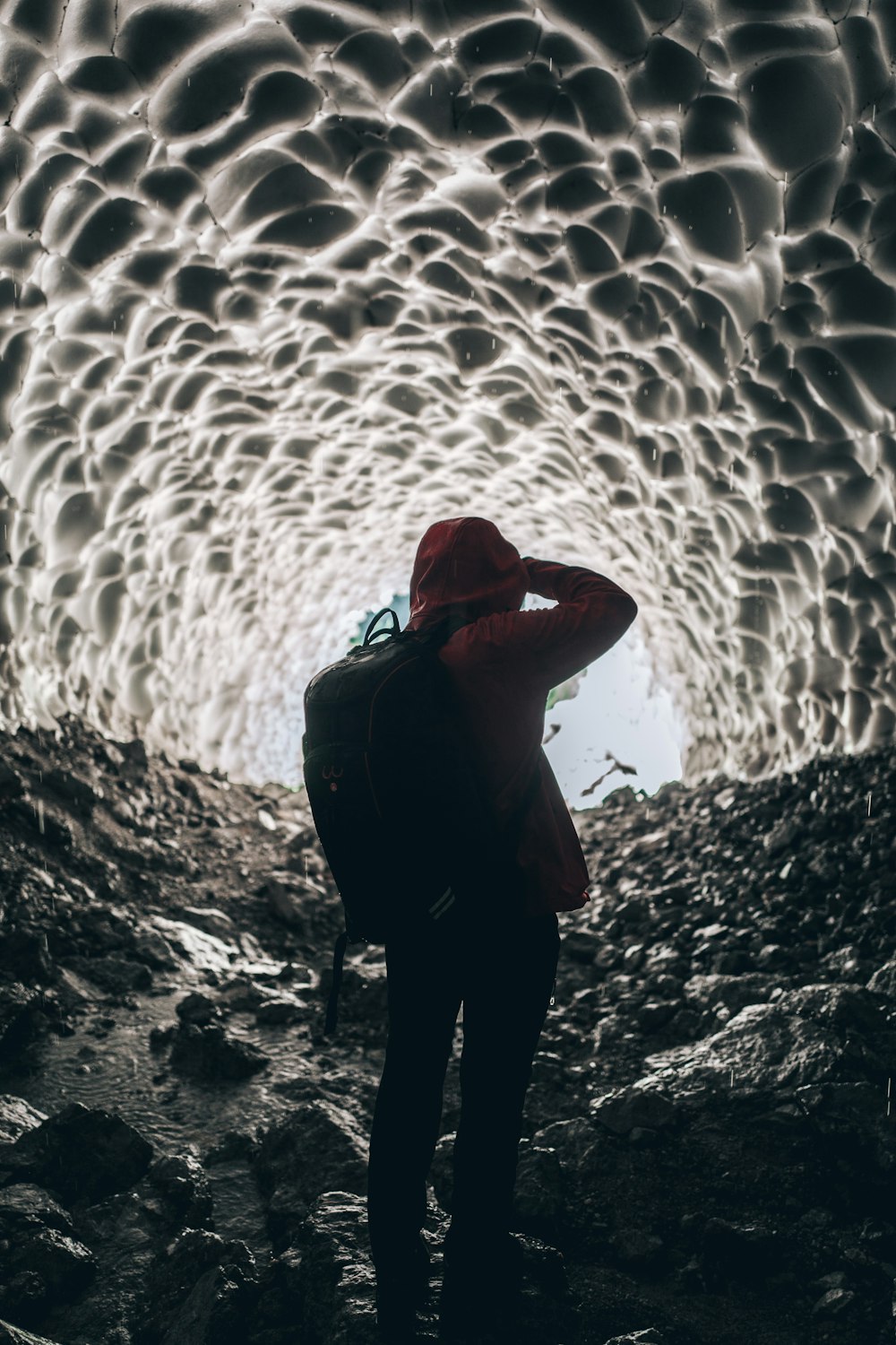 person wearing backpack inside cave